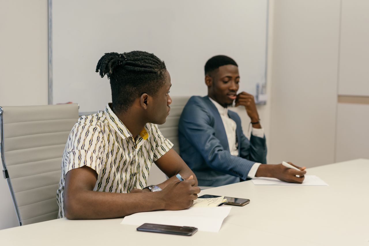 Two colleagues discussing business strategies in a modern office setting.